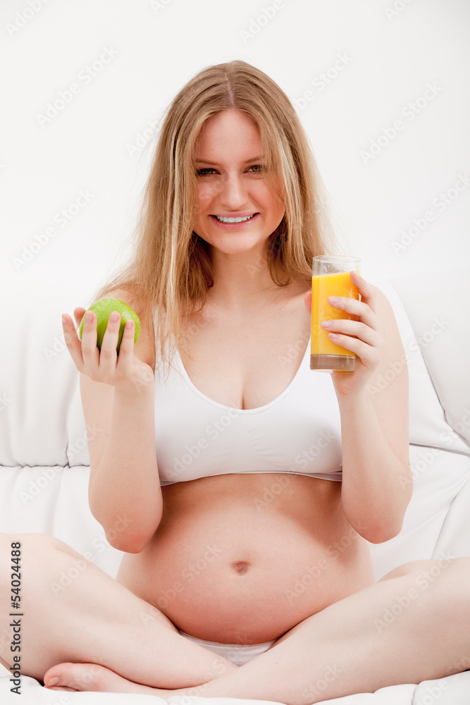 pregnant woman holding an apple and juice pregnant woman holding an apple and juice