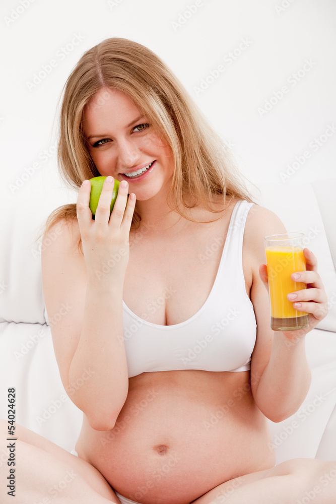 pregnant woman holding an apple and juice pregnant woman holding an apple and juice