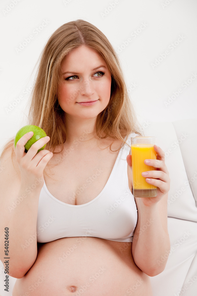 pregnant woman holding an apple and juice pregnant woman holding an apple and juice