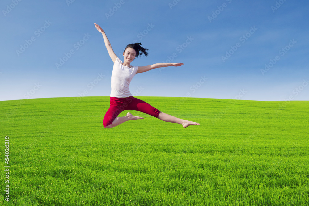 Beautiful dancer jumping above green field Beautiful dancer jumping above green field