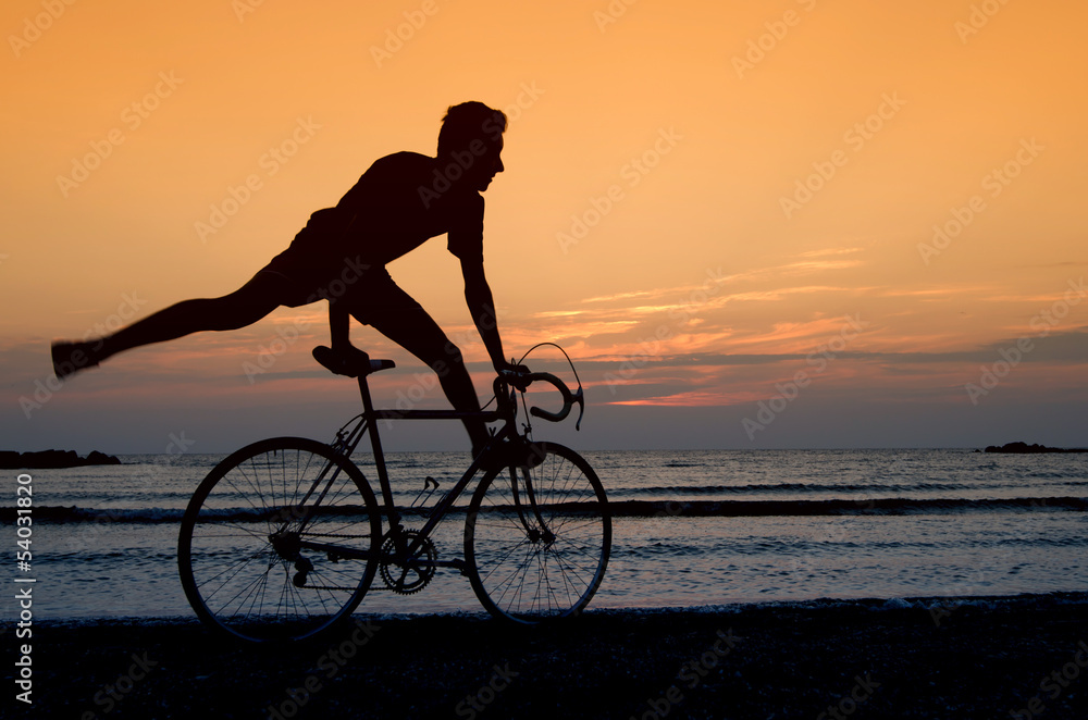 Riding a bicycle at the sunrise on the beach