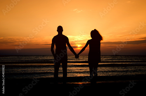 Couple enjoying their time at the sunrise on the beach