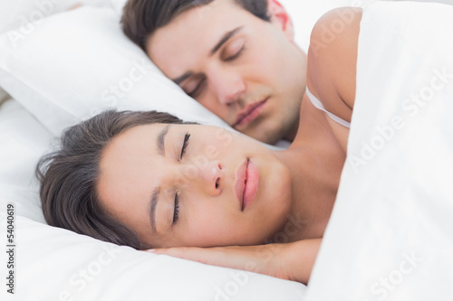 Portrait of an attractive woman sleeping next to her partner