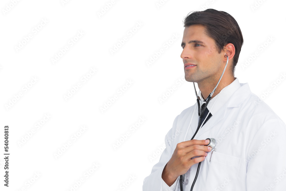 Smiling doctor holding up stethoscope to his chest Smiling doctor holding up stethoscope to his chest