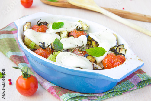 Mixed vegetable in blue bowl baked in the oven with cheese and b photo