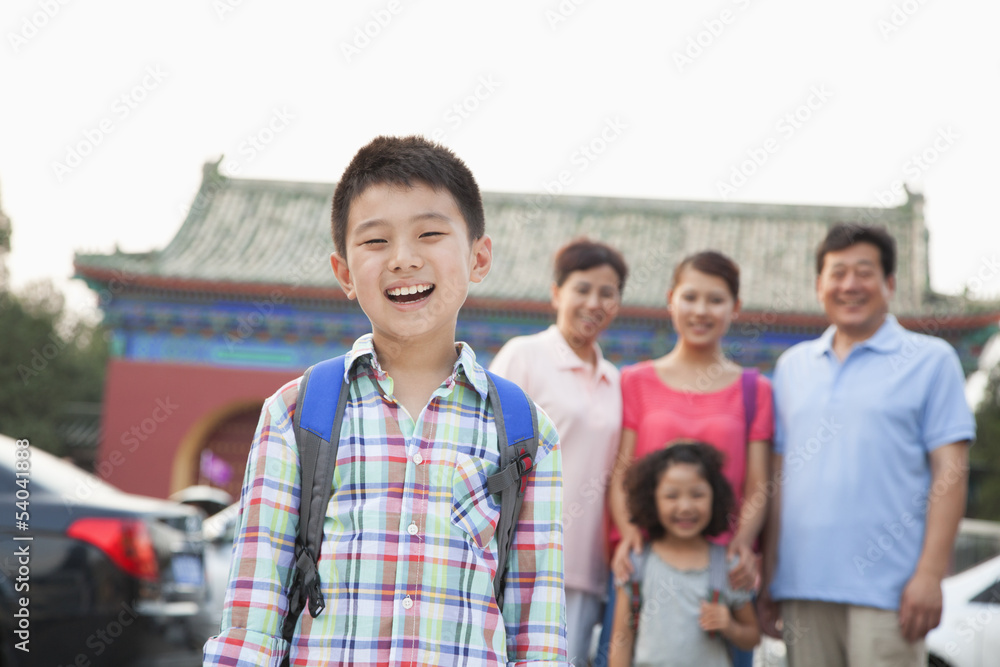 Portrait of boy with his family in the background