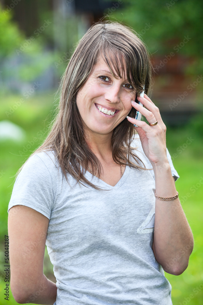 Attractive young woman laughing then calling on the cell phone Attractive young woman laughing then calling on the cell phone