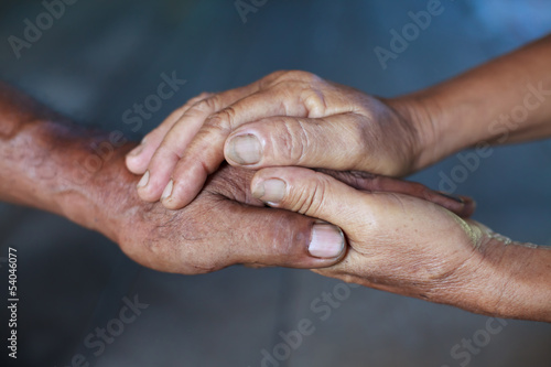 Hand of an elderly woman holding the hand of an elderly man. © Bluesky60
