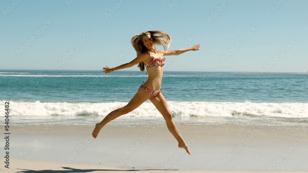 Happy young woman jumping on beach Happy young woman jumping on beach