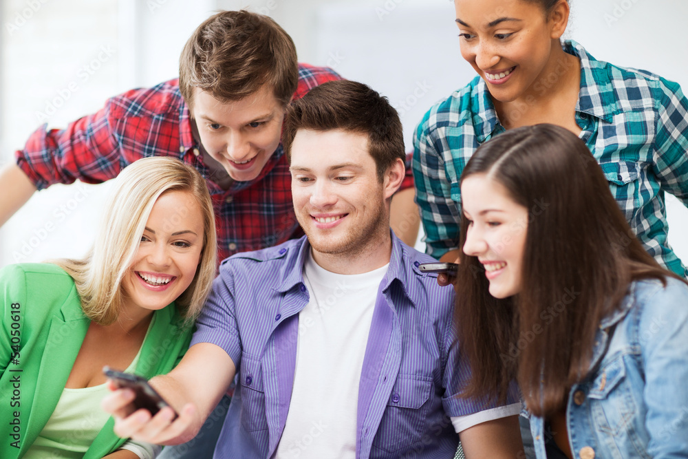 students looking into smartphone at school