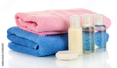 Hotel cosmetic bottles with towel isolated on white