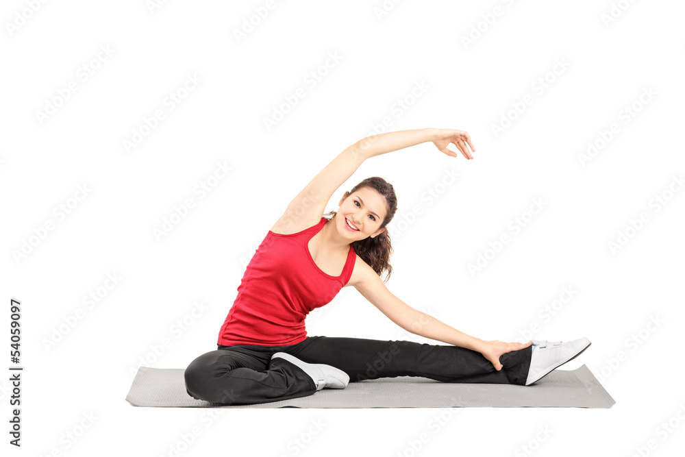 Young female athlete exercising on a mat