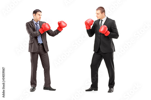 Two businessmen having a fight with boxing gloves