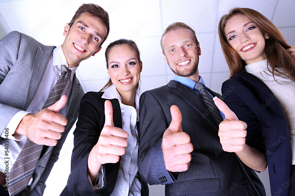 Business team showing thumbs up in office Business team showing thumbs up in office