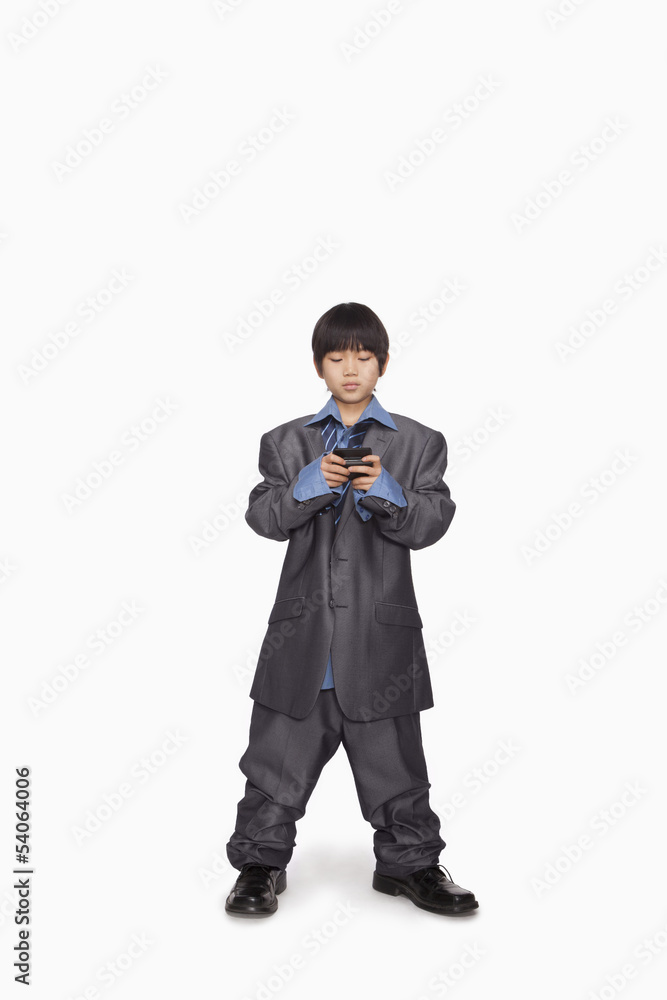 Boy dressed up as businessman checking cell phone Boy dressed up as businessman checking cell phone