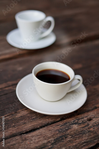Two cups of espresso on a wooden table