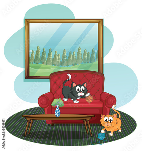 Two kittens playing at the sofa