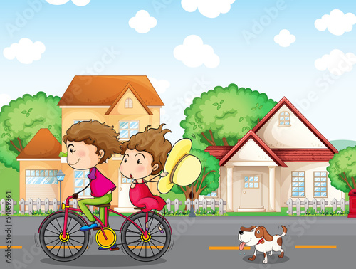 A boy and a girl biking followed by a dog