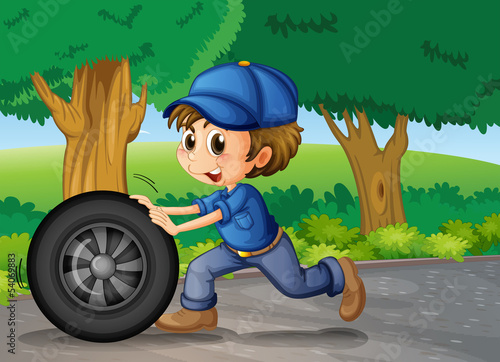 A boy wearing a cap pushing a wheel