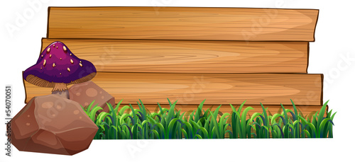 An empty wooden signboard at the back of a mushroom, rocks and g