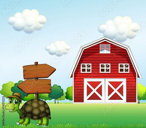 A turtle with a wooden arrow board and a barn at the back