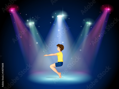 A man at the center of the stage doing yoga