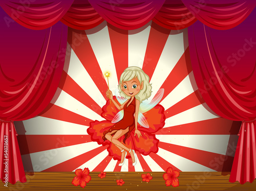 A stage with a fairy in a red dress