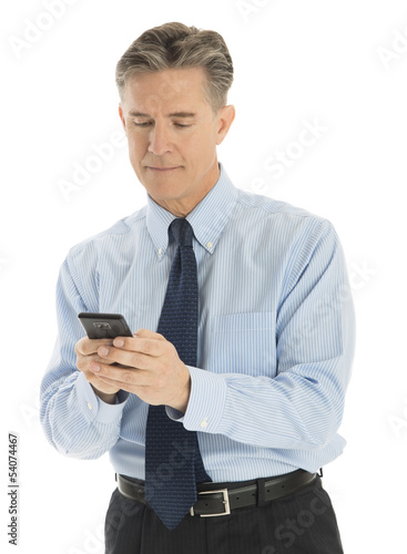 Mature Businessman Text Messaging Through Mobile Phone
