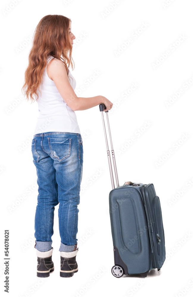 Back view of stylishly dressed woman with suitcase looking up Back view of stylishly dressed woman with suitcase looking up