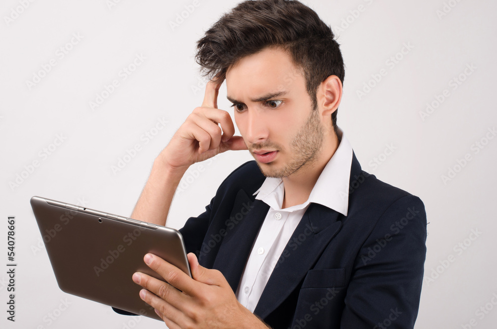 Young beautiful businessman working on a tablet Young beautiful businessman working on a tablet