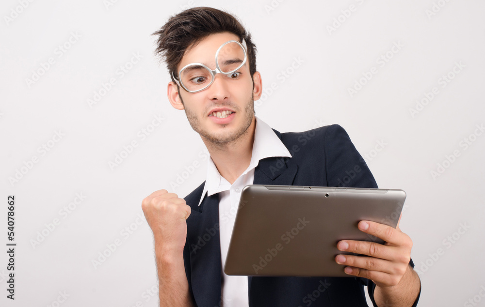 Young businessman using a tablet and getting good news Young businessman using a tablet and getting good news