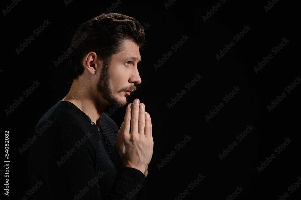 Man praying to God. Side view of bearded man praying and holding Man praying to God. Side view of bearded man praying and holding