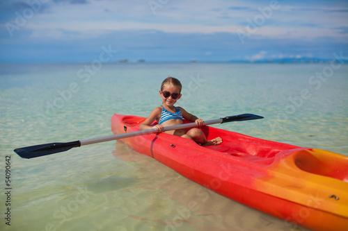brave little cute girl floating in a kayak on the high seas