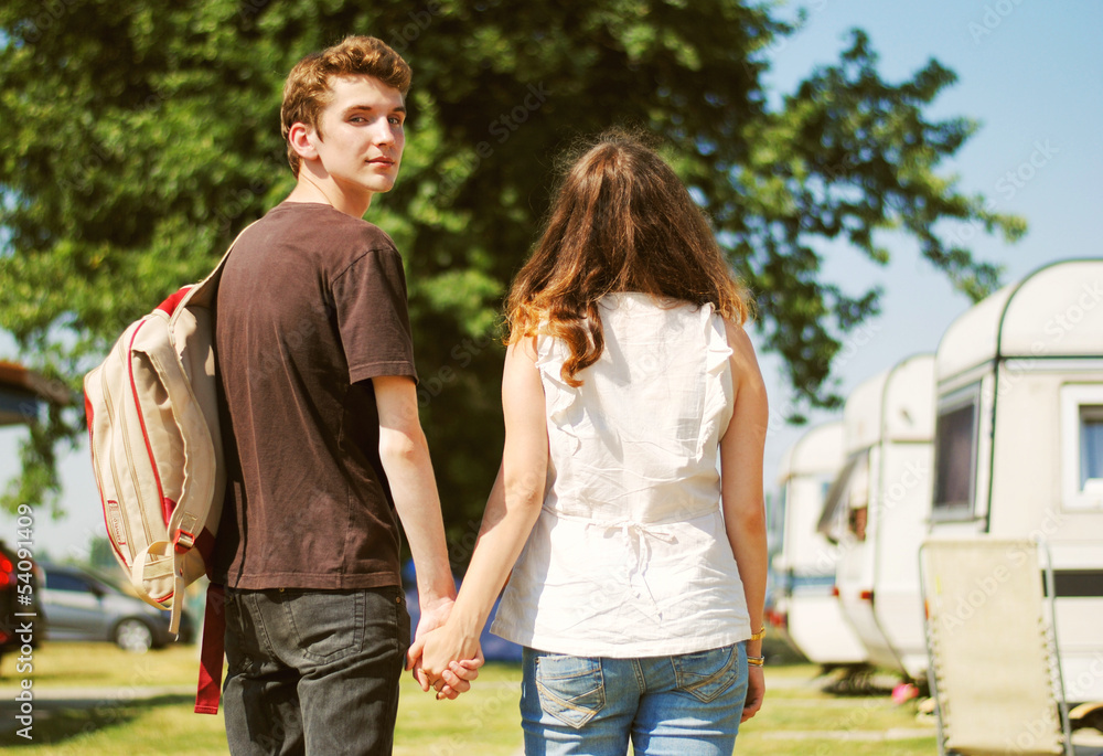 Fototapeta premium Teenage couple walk touching hand in hand