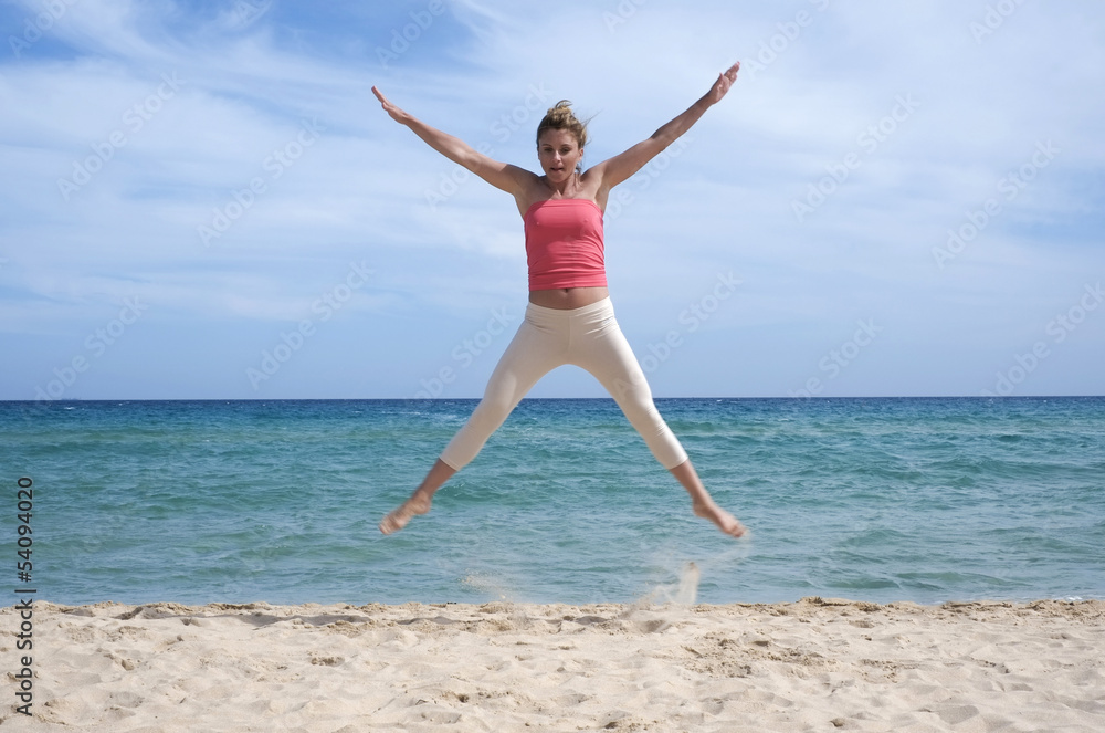Girl jumping on the beach in Sardinia
