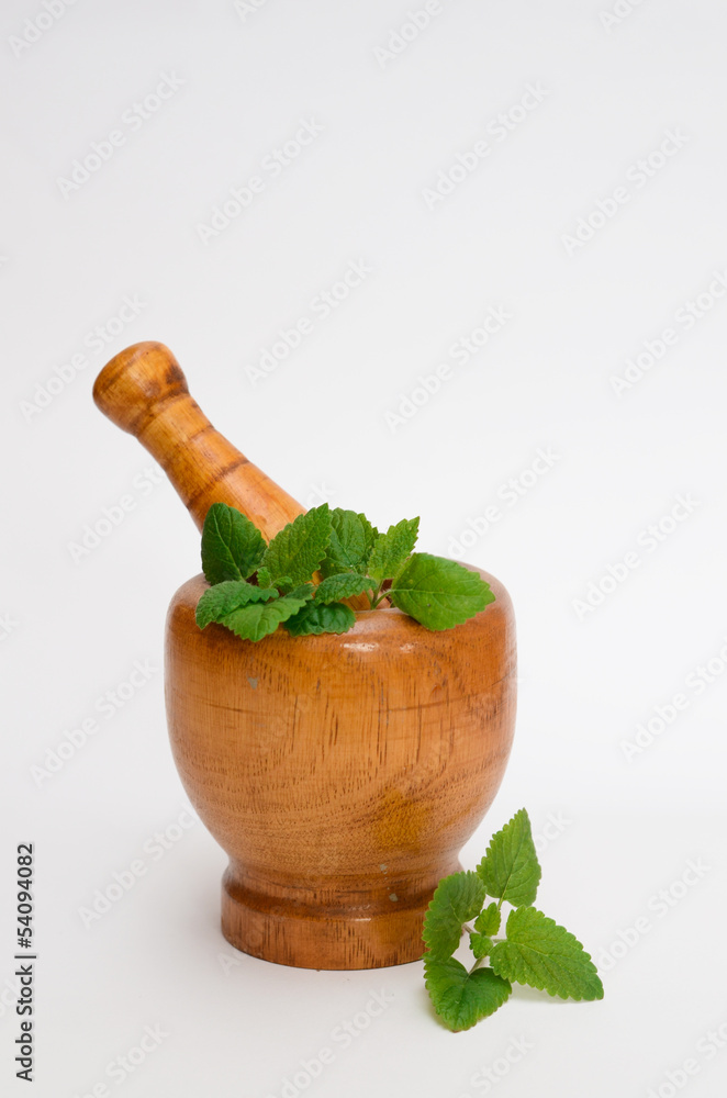 wooden mortar with melissa leaves
