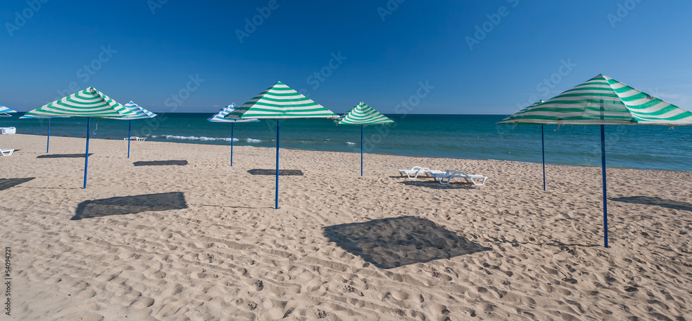 beach with chairs and thatched umbrellas