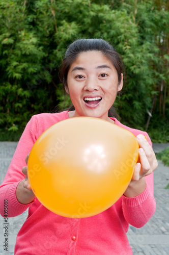 A Chinese woman holding balloons © ABCDstock