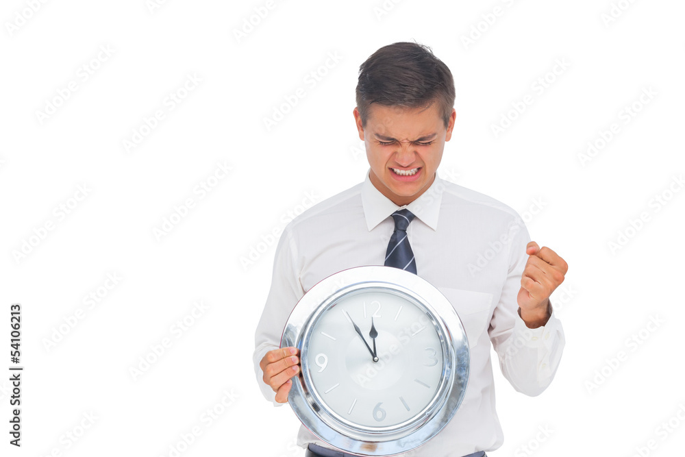 Excited businessman holding a clock Excited businessman holding a clock