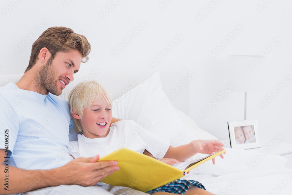 Portrait of a smiling father reading a story to his son Portrait of a smiling father reading a story to his son