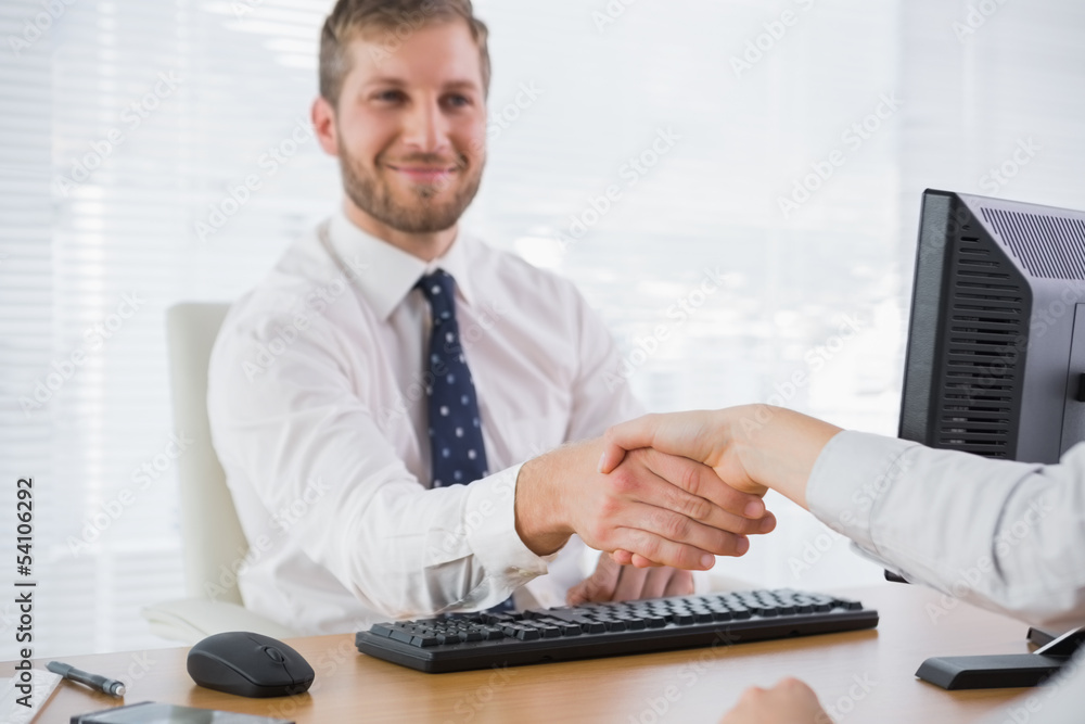 Happy businessman shaking hands with a co worker Happy businessman shaking hands with a co worker