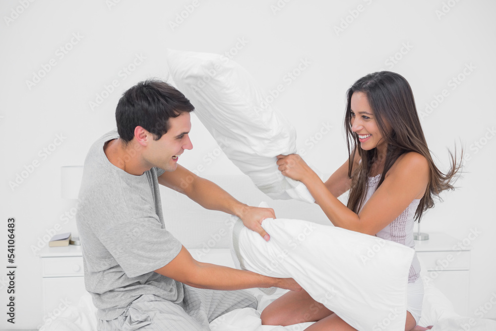 Obraz premium Couple fighting together with pillows