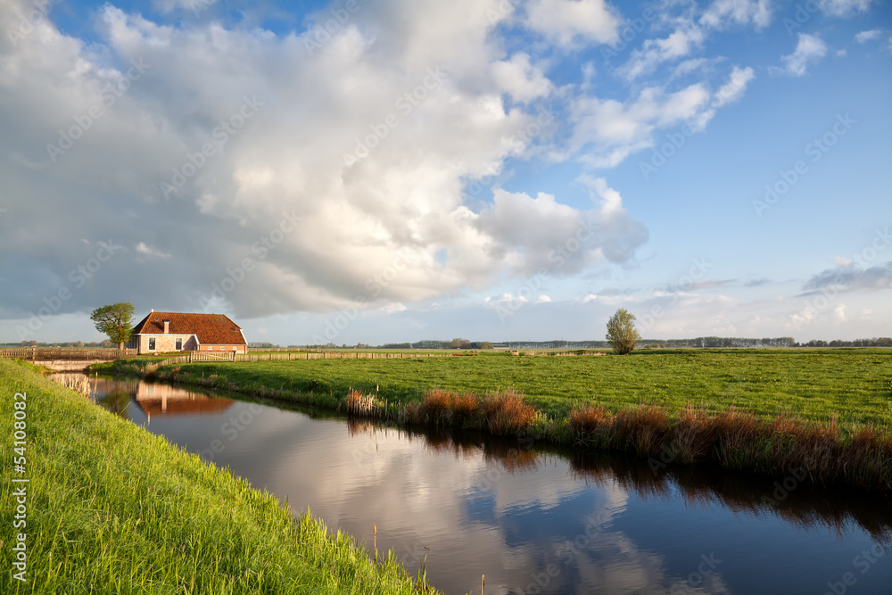 Fototapeta premium charming farmhouse, river and blue sky