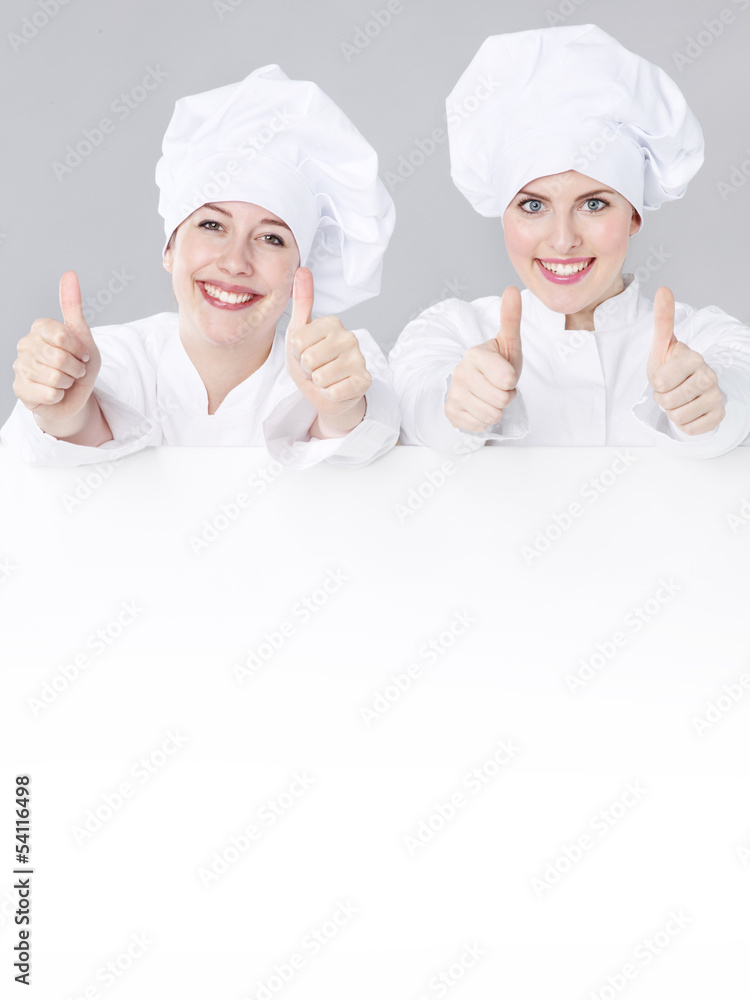 Female cooks show white blackboard with copyspace Female cooks show white blackboard with copyspace