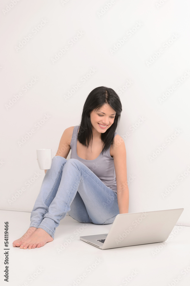 Surfing web and drinking coffee. Beautiful young woman using com Surfing web and drinking coffee. Beautiful young woman using com