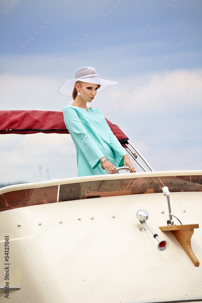woman with steering wheel showing thumb up on the yacht