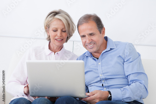Happy Mature Couple Working On Laptop