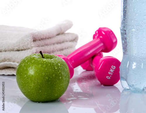 Towel, water, apple, dumbells lying isolated on white