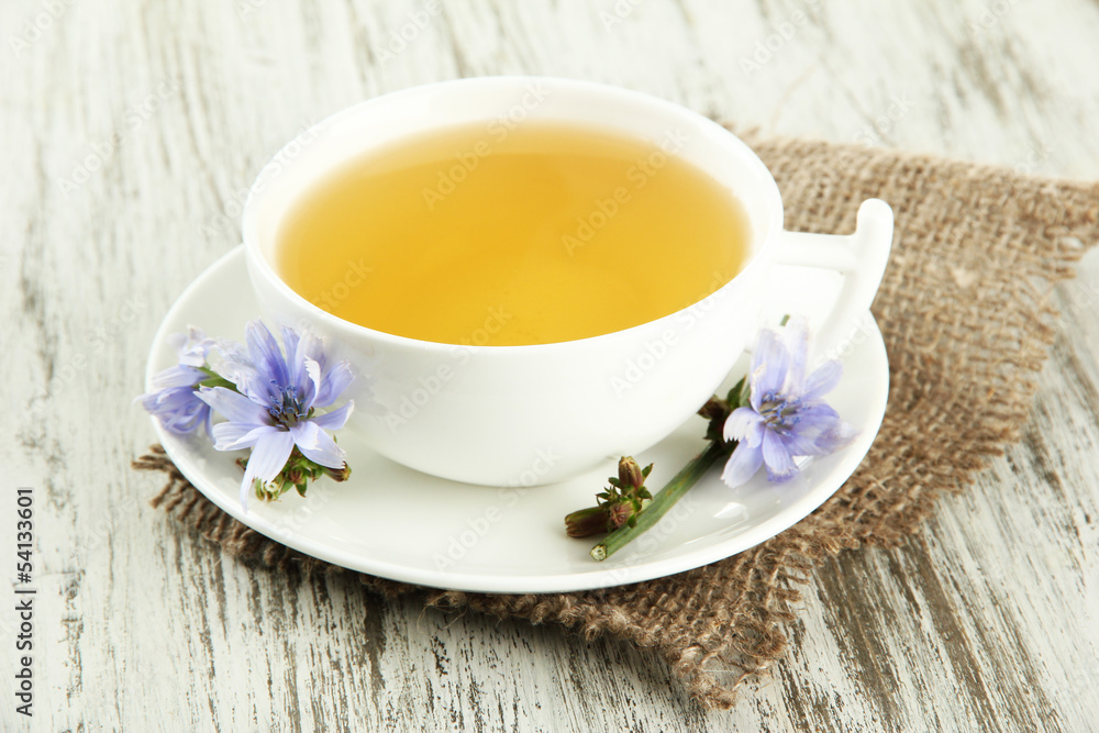 Cup of tea with chicory, on wooden background Cup of tea with chicory, on wooden background