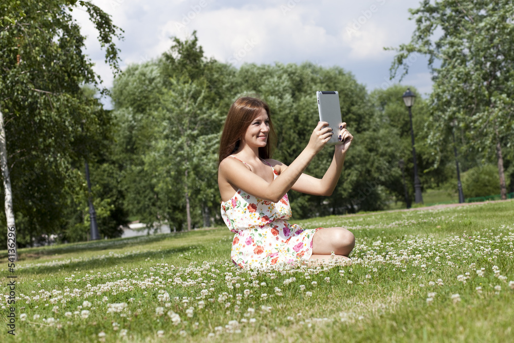 Portrait of young woman sitting on a green lawn Portrait of young woman sitting on a green lawn